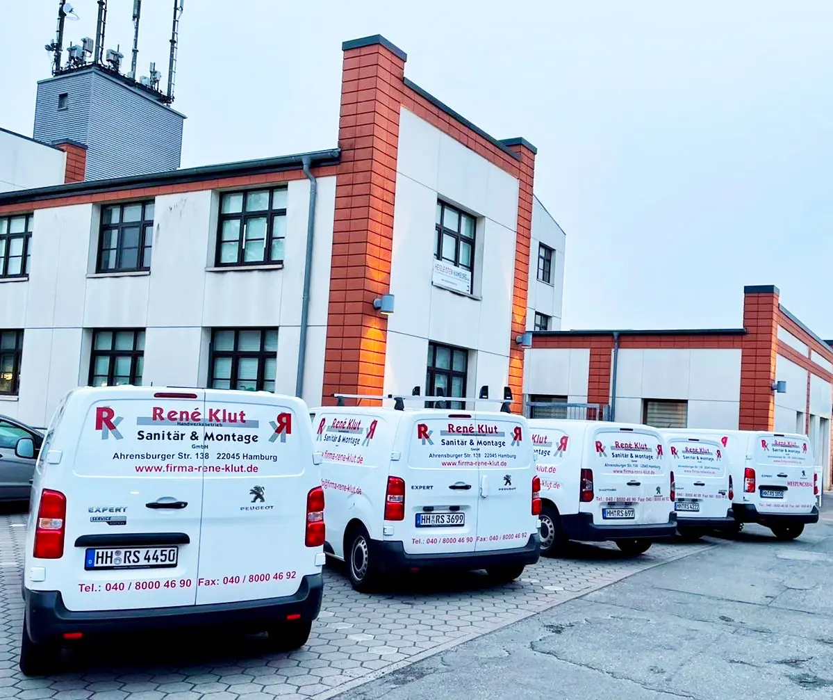 Firmenfahrzeuge von René Klut vor einem Betriebsgebäude
